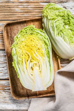 Çin lahanası kesiyorum. Organik sebzeler. Beyaz ahşap arka plan. Üst görünüm.