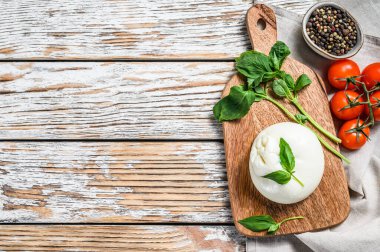 İtalyan mozzarella Burrata peyniri ve fesleğen yaprağı. Caprese salatası. Beyaz arka plan. Üst görünüm.