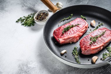 Çiğ mermer biftek, üst bıçak bifteği. Gri arka plan. Üst Manzara. Boşluğu kopyala.