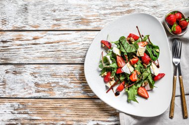 Camembert salatası, çilek, fındık, pazı ve roka. Beyaz arka plan. Üst Manzara. Boşluğu kopyala.
