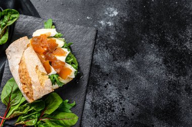 Keçi peynirli armut bruschetta, pazı ve balzamik sirke. Siyah arka plan. Üst Manzara. Boşluğu kopyala.