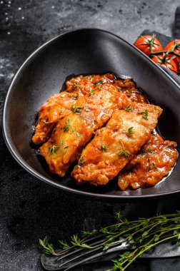 Fırında Tilapia balığı ve domates tabağı. Siyah arka plan. Üst görünüm.