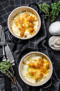 Julienne, tavuk ve mantarlı ve porsiyon şeklinde. Siyah arka plan. Üst görünüm.