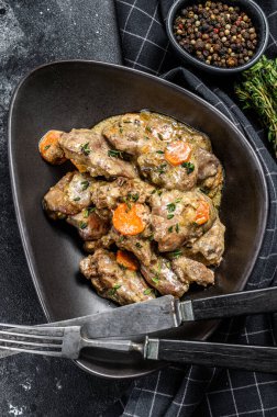 Tavuk, hindi ciğeri yahnisi ve tabakta soğan. Siyah arka plan. Üst görünüm.