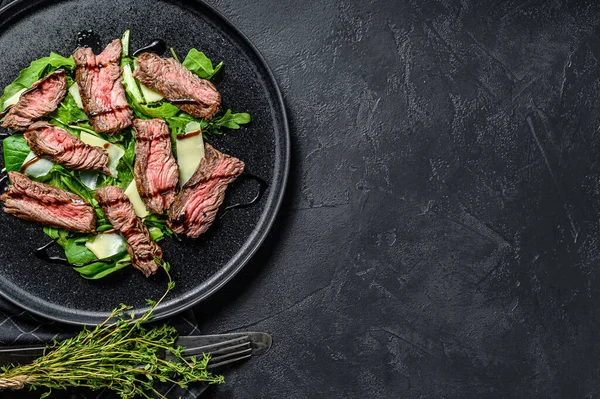 牛排沙拉配菠菜 牛油条和切碎的牛肉肉片 黑色背景 顶部视图 复制空间 — 图库照片