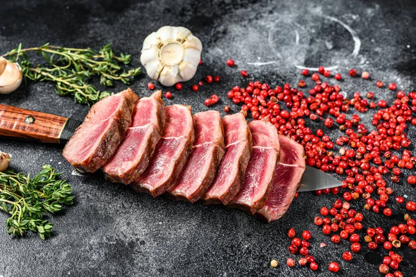 Sliced ready to eat steak Top Blade beef breeds, black Angus meat. Black background. Top view.