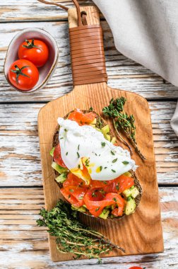 Izgara tost üzerine somon ve haşlanmış yumurta. Beyaz ahşap arka plan. Üst görünüm.