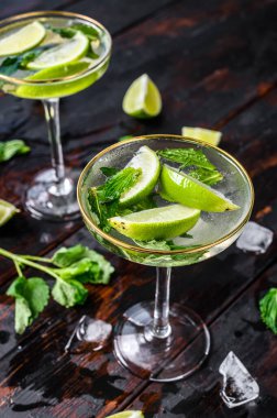 Taze limonata mojito. Naneli mojito, limon ve buz. Siyah ahşap arka plan. Üst görünüm.