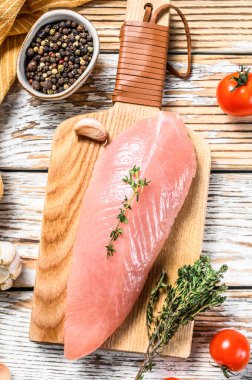 Çiğ hindi bifteği. Otlu göğüs filetosu. Beyaz ahşap arka plan. Üst görünüm.