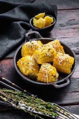 Sarımsak ve tereyağlı kavrulmuş ya da ızgara mısır koçanı. Karanlık ahşap arka plan. Üst görünüm.