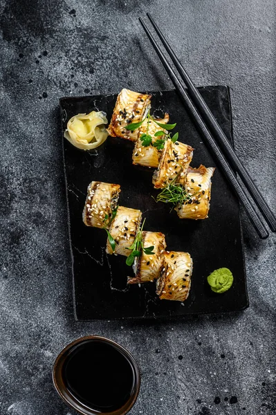 Suşi, Maki suşisi, füme yılan balığı ve salatalık. Siyah arka plan. Üst görünüm.