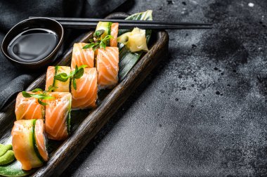 Somon, karides, avokado ve krem peynirli Philadelphia maki suşisi. Suşi rulo menüsü. Siyah arka plan. Üst Manzara. Boşluğu kopyala.