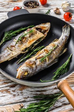 BBQ deniz levreği, tavada kızarmış levrek. Beyaz ahşap arka plan. Üst görünüm.