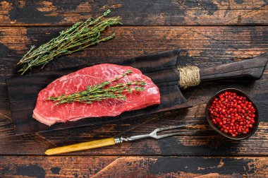 Çiğ biftek, sığır eti. Karanlık ahşap arka plan. Üst görünüm.