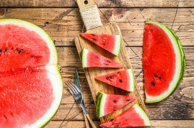 Bir yığın taze kırmızı dilimlenmiş karpuz. Ahşap arka plan. Üst görünüm.