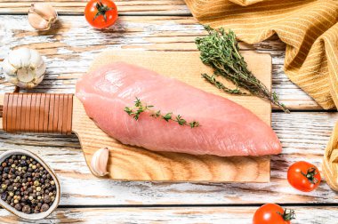 Çiğ hindi bifteği. Otlu göğüs filetosu. Beyaz ahşap arka plan. Üst görünüm.