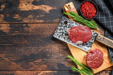 Kesme tahtasında çiğ mermer et fileto mignon. Karanlık ahşap arka plan. Üst Manzara. Boşluğu kopyala.