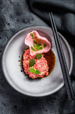Japon usulü taze somon tartare. Siyah arka plan. Üst görünüm.