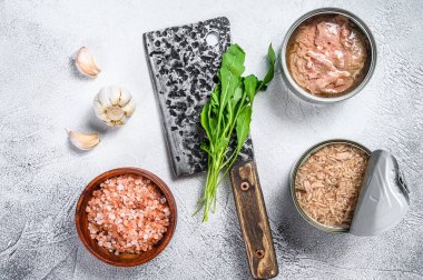 Konserve ton balığı konservesi, bütün ve doğranmış. Gri ahşap arka plan. Üst görünüm.