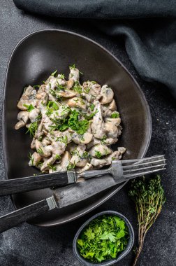 Krematoryumlu ve mantarlı biftek stroganoff. Siyah arka plan. Üst görünüm.