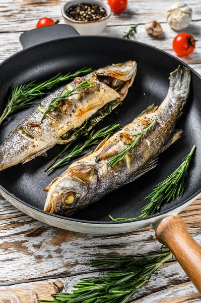 BBQ deniz levreği, tavada kızarmış levrek. Beyaz ahşap arka plan. Üst görünüm.