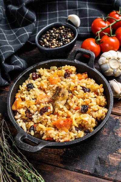 Tavada pilav. Orta Asya mutfağı Plov. Koyu ahşap arka plan. Üst görünüm.