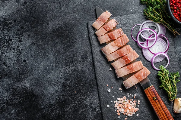 Soğan ve kekik ile dilimlenmiş salamura fileto. Siyah arka plan. Üst Manzara. Boşluğu kopyala.