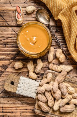 Cam kavanozdaki taze kremalı fıstık ezmesi. Ahşap arka plan. Üst görünüm.