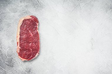 Striploin bifteği ya da çiğ New York. Gri arka plan. Üst Manzara. Boşluğu kopyala.