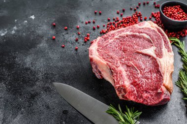 Çiğ kovboy bifteği ya da kemiğe otlar sürülmüş pirzola. Mermer biftek. Siyah arka plan. Üst Manzara. Boşluğu kopyala