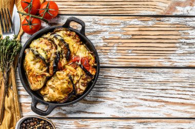 Dökme demir tabakta pişirilmiş sebzeli ratatouille. Ahşap arka plan. Üst Manzara. Boşluğu kopyala.