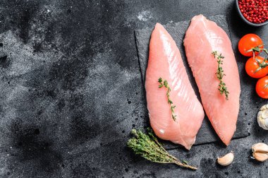 Çiğ hindi göğsü. Biftek. Siyah arka plan. Üst Manzara. Boşluğu kopyala.