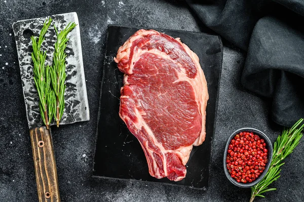 Pirzola ya da kovboy bifteği. Çiğ mermer sığır eti, siyah Angus, pirzola. Arka plan. Üst görünüm.