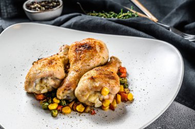 Beyaz tabakta sebzeli ızgara tavuk budu. Beyaz arka plan. Üst görünüm.