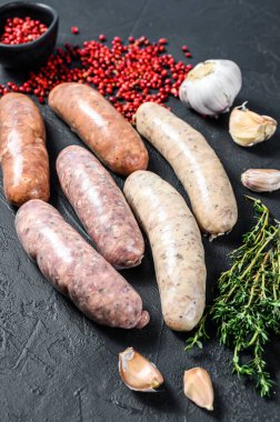 Baharatlı taze çiğ sosis. Siyah arka plan. Üst görünüm.