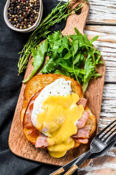 Pastırmalı Brioche sandviç, Benedict usulü yumurta ve Hollandaise sosu. Beyaz arka plan. Üst görünüm.