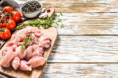 Kesme tahtasıyla küp kesilmiş çiğ tavuk filetosu. Beyaz arka plan. Üst Manzara. Metin için boşluk