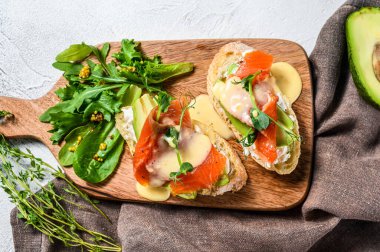 Avokado ve somonlu sağlıklı sandviç. Ispanak ve roka salatası. Beyaz arka plan. Üst görünüm.