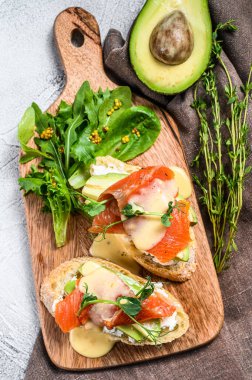 Avokado ve füme somon ile tost. Beyaz arka plan. Üst görünüm.