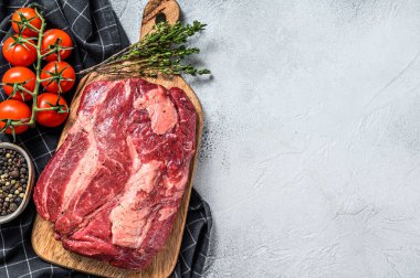 Çiğ Chuck rulo bifteği, otlar ve kesme tahtasında tuz. Gri arka plan. Üst Manzara. Boşluğu kopyala.