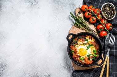 Kızarmış yumurta ve domateslerle kahvaltı. Shakshuka tavada. Geleneksel Türk yemekleri. Gri arka plan. Üst Manzara. Boşluğu kopyala.