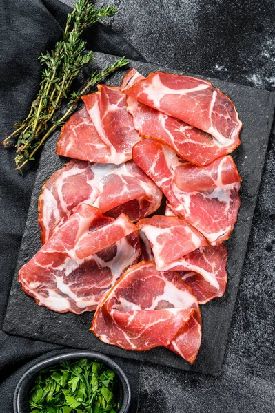 İtalyan usulü pastırmalı Pancetta Piacentina. Domuz eti. Siyah arka plan. Üst görünüm