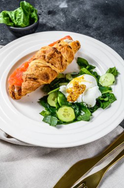 Somon ve ricotta peynirli kruvasan, ıspanaklı ve yumurtalı salata. Arka plan. Üst görünüm.