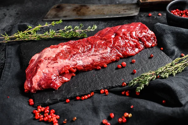 Raw strip vegas beef steak with pink pepper and thyme. Black background. Top view.