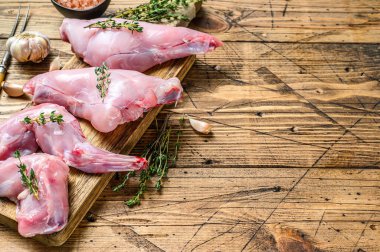 Kesme tahtasında çiğ tavşan bacağı. Ahşap arka plan. Üst Manzara. Boşluğu kopyala.