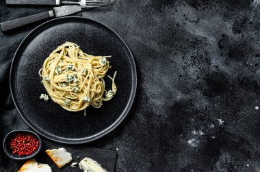 Mavi Gorgonzola peynirli spagetti makarna. Siyah arka plan. Üst Manzara. Boşluğu kopyala.