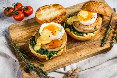 Balık fileto, yumurta ve ıspanaklı nefis balık burgeri. Gri arka plan. Üst görünüm.