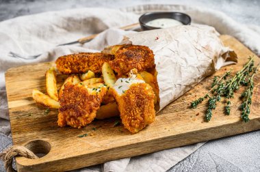 Balık ve patates kızartması. İngiliz fast food 'u. Tatar sosuyla servis ediliyor. Gri arka plan. Üst görünüm.