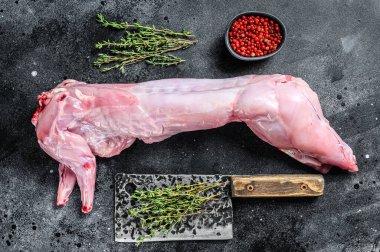 Pişirmek için baharatlı çiğ tavşan eti. Siyah arka plan. Üst görünüm.