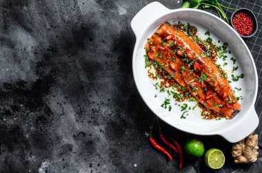 Teriyaki usulü alabalık pişiriyorum. Siyah arka plan. Üst Manzara. Boşluğu kopyala.